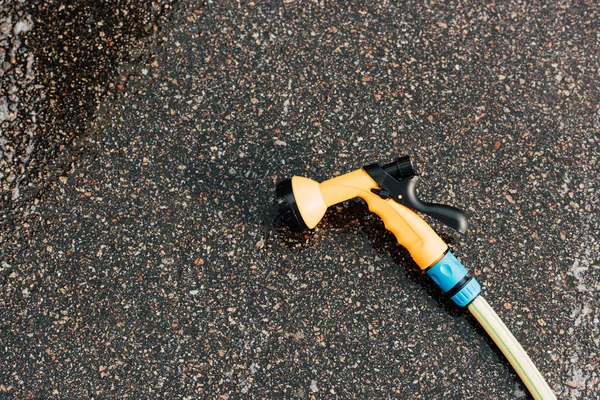 Moderner Hochdruckreiniger auf grauem und nassem Asphalt — Stockfoto