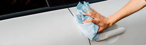 Tiro panorâmico de jovem mulher polimento carro branco — Fotografia de Stock