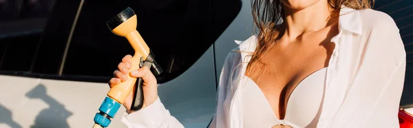 Colpo panoramico della donna che tiene la rondella di pressione vicino all'auto bianca — Foto stock