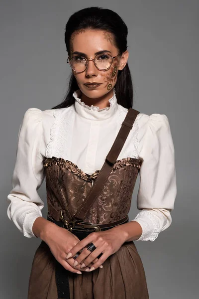 Attractive steampunk woman in glasses with makeup isolated on grey — Stock Photo