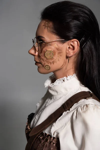 Side view of steampunk girl in white blouse with makeup on grey — Stock Photo