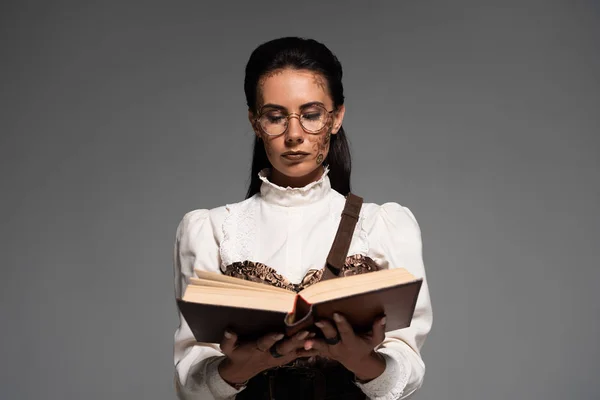 Frontansicht einer fokussierten Steampunk-Frau, die Buch isoliert auf grau liest — Stockfoto