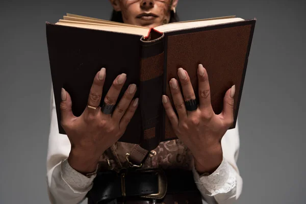 Cropped view of steampunk woman reading book isolated on grey — Stock Photo