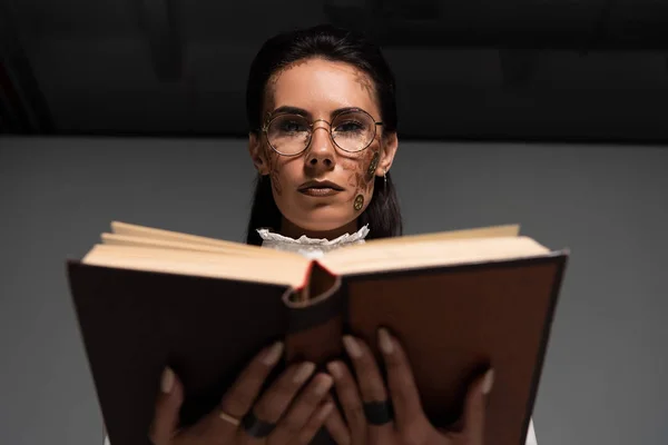 Foco seletivo da mulher steampunk em óculos livro de leitura — Fotografia de Stock