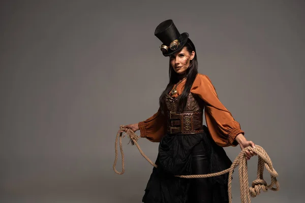 Attrayant steampunk fille dans chapeau haut tenant lasso isolé sur gris — Photo de stock