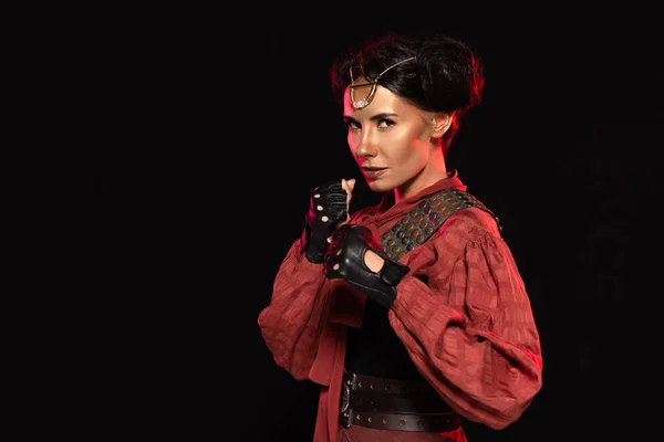 Confident steampunk girl holding fists up and looking at camera isolated on black — Stock Photo