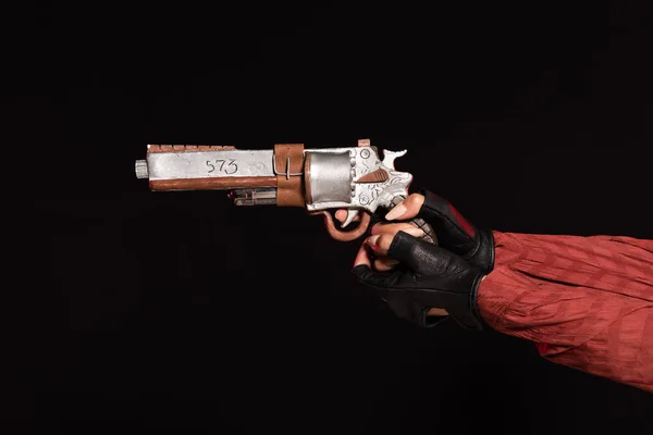 Cropped view of young woman in leather gloves holding pistol isolated on black — Stock Photo