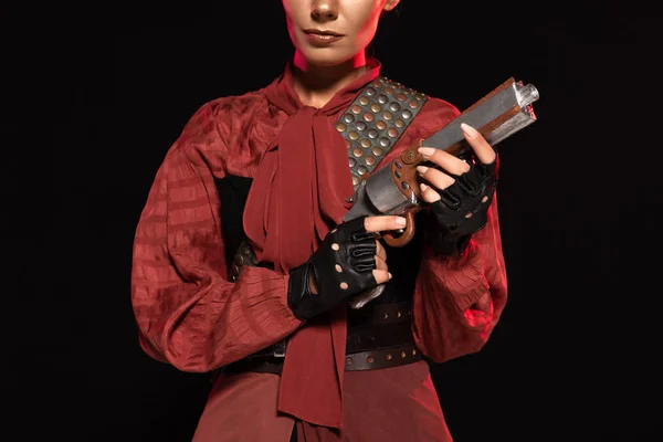 Cropped view of steampunk young woman holding pistol isolated on black — Stock Photo