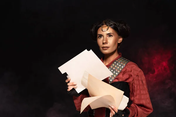 Dreamy attractive steampunk young woman holding papers on black — Stock Photo