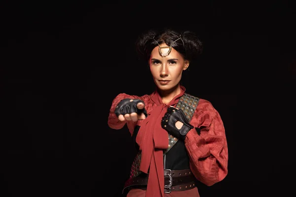 Front view of beautiful steampunk woman pointing with finger at camera isolated on black — Stock Photo