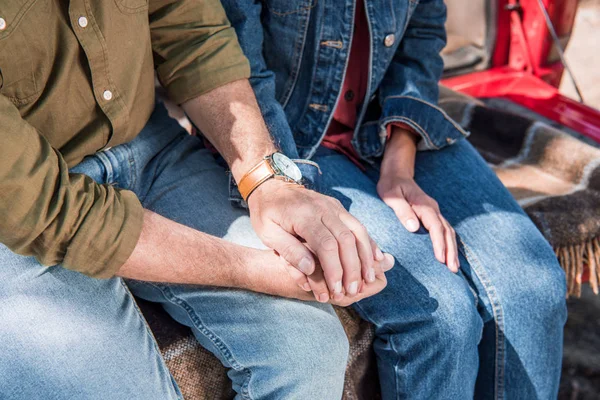 Vista recortada de pareja mayor en jeans tomados de la mano - foto de stock