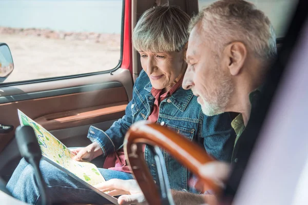 Вибірковий фокус старшої пари, дивлячись на карту в машині — стокове фото