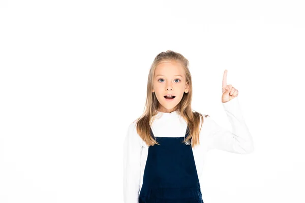 Entzückendes Schulmädchen, das in die Kamera schaut und mit dem Finger auf Weiß zeigt — Stockfoto