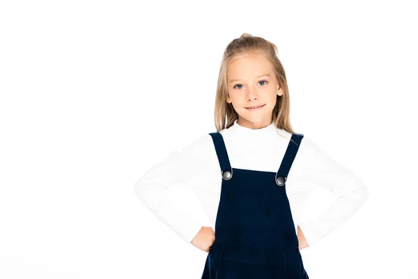 Carino studentessa sorridente mentre posa a macchina fotografica con le mani sui fianchi isolato su bianco — Foto stock