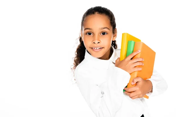 Mignon afro-américain écolière tenant livre tout en regardant caméra isolé sur blanc — Photo de stock