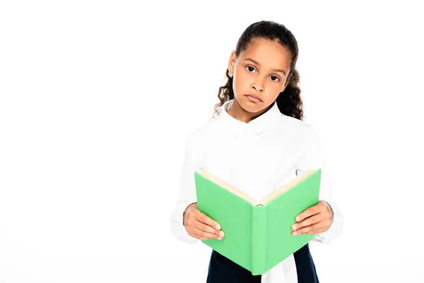 Aufgebrachte afrikanisch-amerikanische Schülerin blickt in die Kamera, während sie Buch isoliert auf weiß hält — Stockfoto