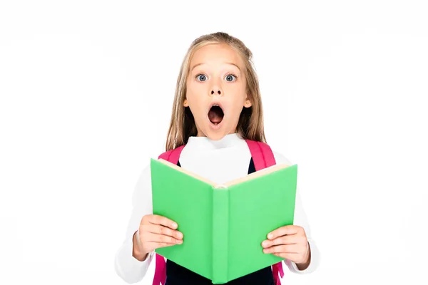 Schockiertes Schulmädchen hält Buch in der Hand, während es in die Kamera schaut — Stockfoto