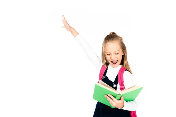 Excited schoolgirl showing yes gesture while reading book isolated on white — Stock Photo