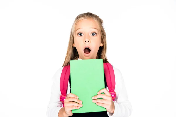 Schockiertes Schulmädchen hält Buch in der Hand, während es in die Kamera schaut — Stockfoto
