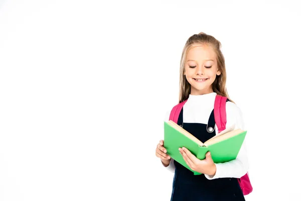 Entzückendes Schulmädchen lächelt, während es Buch isoliert auf weiß liest — Stockfoto