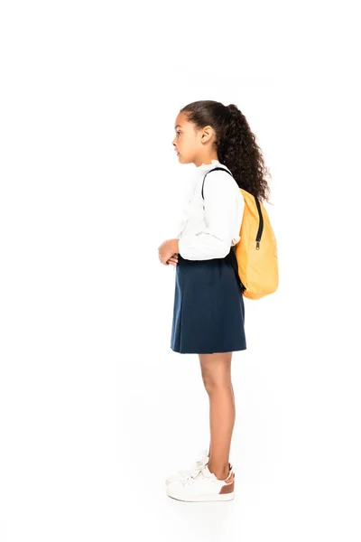 Vista lateral da estudante americana africana com mochila amarela no fundo branco — Fotografia de Stock