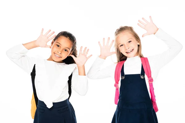 Zwei lächelnde multikulturelle Schulmädchen, die kreidebefleckte Hände zeigen, isoliert auf weiß isoliert auf weiß — Stockfoto