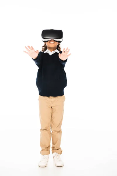 Volle Länge Ansicht der afrikanisch-amerikanischen Schulmädchen mit ausgestreckten Händen stehen, während mit Virtual-Reality-Headset auf weißem Hintergrund — Stockfoto