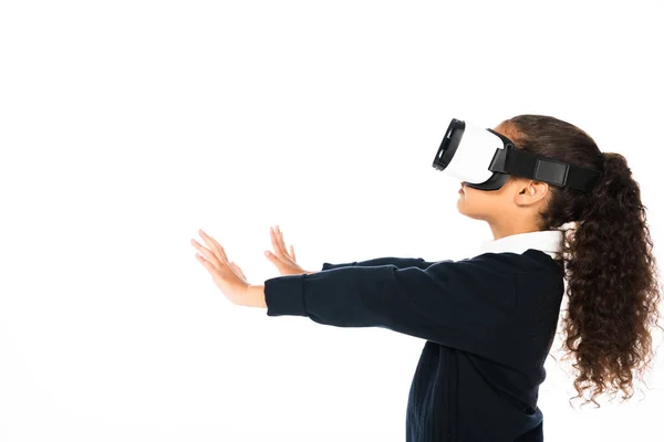 Afro-américaine écolière avec les mains tendues en utilisant un casque de réalité virtuelle isolé sur blanc — Photo de stock