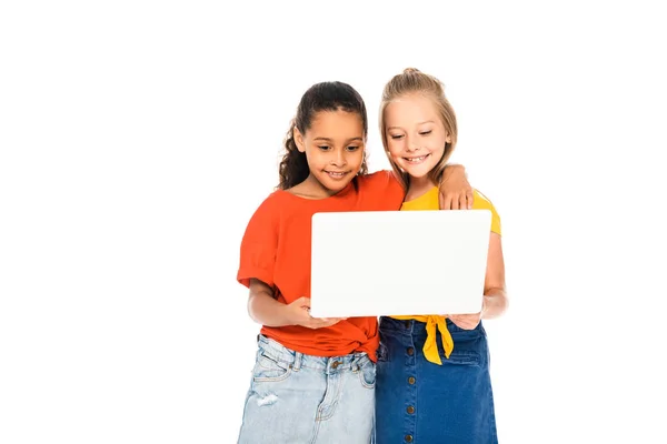 Zwei entzückende Kinder lächeln, während sie zusammen Laptop isoliert auf weiß benutzen — Stockfoto