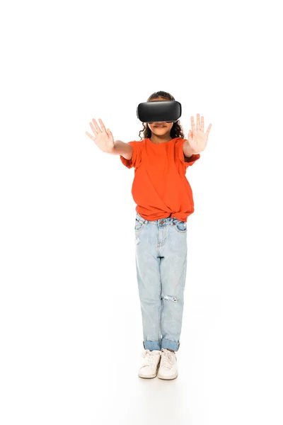 Full length view of african american child standing with outstretched hands while using virtual reality headset on white background — Stock Photo