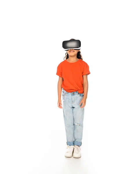 Full length view of smiling african american kid using virtual reality headset on white background — Stock Photo