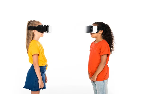 Deux amis multiculturels se regardant tout en utilisant des casques de réalité virtuelle isolés sur blanc — Photo de stock