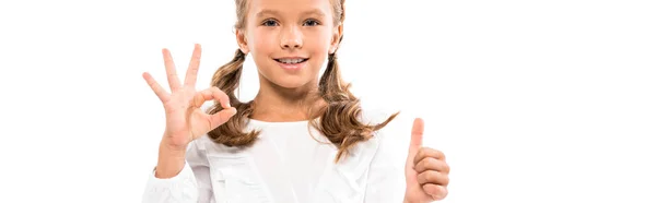 Plano panorámico de niño feliz mostrando el pulgar hacia arriba y ok signo aislado en blanco - foto de stock