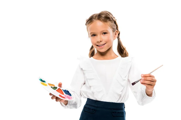 Positive kid holding colorful watercolor palette isolated on white — Stock Photo