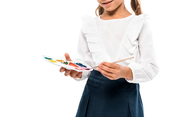Vue recadrée d'un enfant heureux tenant une palette d'aquarelles isolée sur blanc — Photo de stock