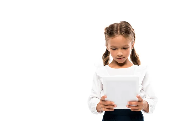 Cute schoolkid using digital tablet isolated on white — Stock Photo