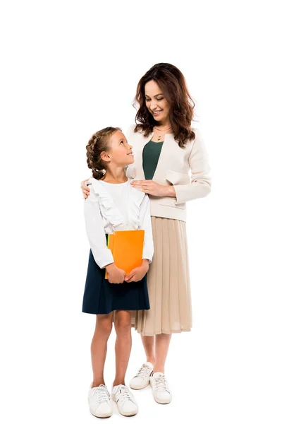 Glückliche Mutter mit fröhlicher Tochter, die Bücher isoliert auf Weiß hält — Stockfoto
