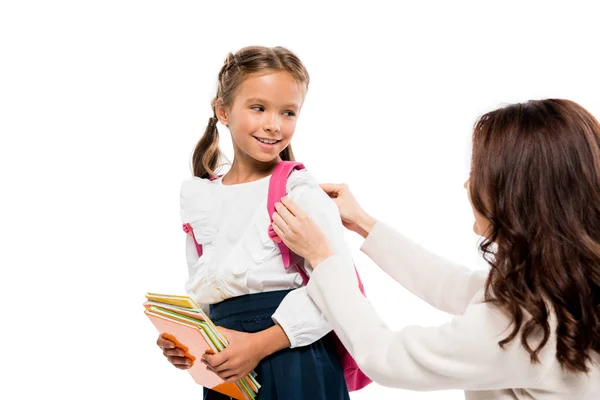 Mãe tocando mochila de filha feliz isolado no branco — Fotografia de Stock