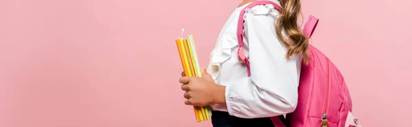 Plan panoramique d'enfant tenant des livres et se tenant isolé sur rose — Photo de stock