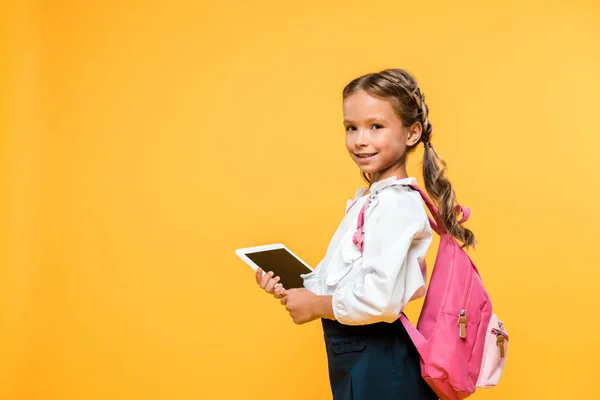 Щасливий школяр тримає цифровий планшет з порожнім екраном ізольовано на помаранчевому — стокове фото