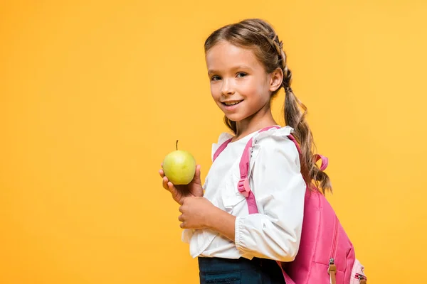 Happy schoolchild holding tasty apple isolated on orange — Stock Photo