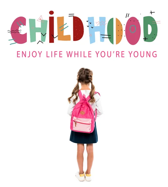 Back view of schoolchild standing with pink backpack near childhood lettering on white — Stock Photo