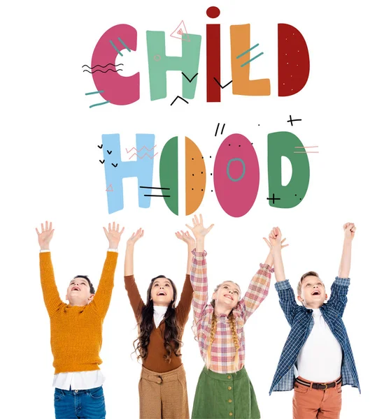 Cheerful schoolchildren with outstretched hands near childhood letters on white — Stock Photo