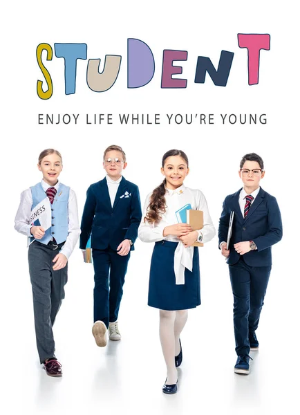 Schoolchildren pretending to be businesspeople with books and newspaper walking near student letters on white — Stock Photo