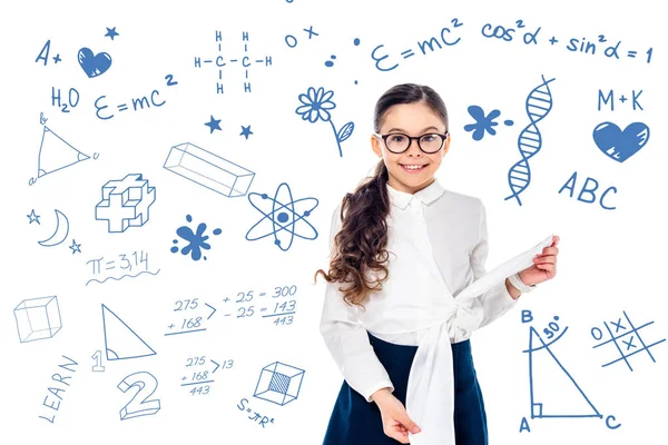 Colegiala sonriente en ropa formal y gafas mirando a la cámara cerca de fórmulas matemáticas en blanco - foto de stock