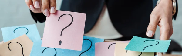 Panoramic shot of woman holding pink sticky note with question mark — Stock Photo