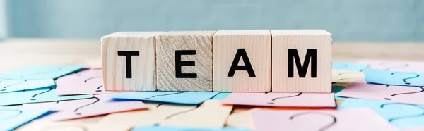 Panoramic shot of team lettering on cubes near sticky notes with question marks — Stock Photo