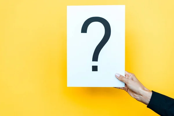 Cropped view of woman holding board with question mark on orange — Stock Photo