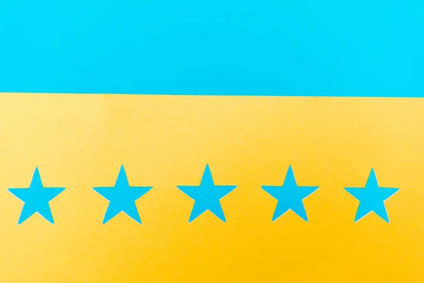Vista dall'alto di stelle blu su sfondo giallo e blu — Foto stock