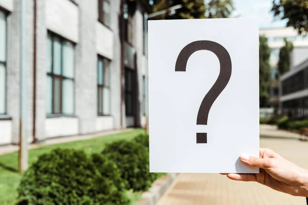 Cropped view of woman holding placard with question mark outside — Stock Photo